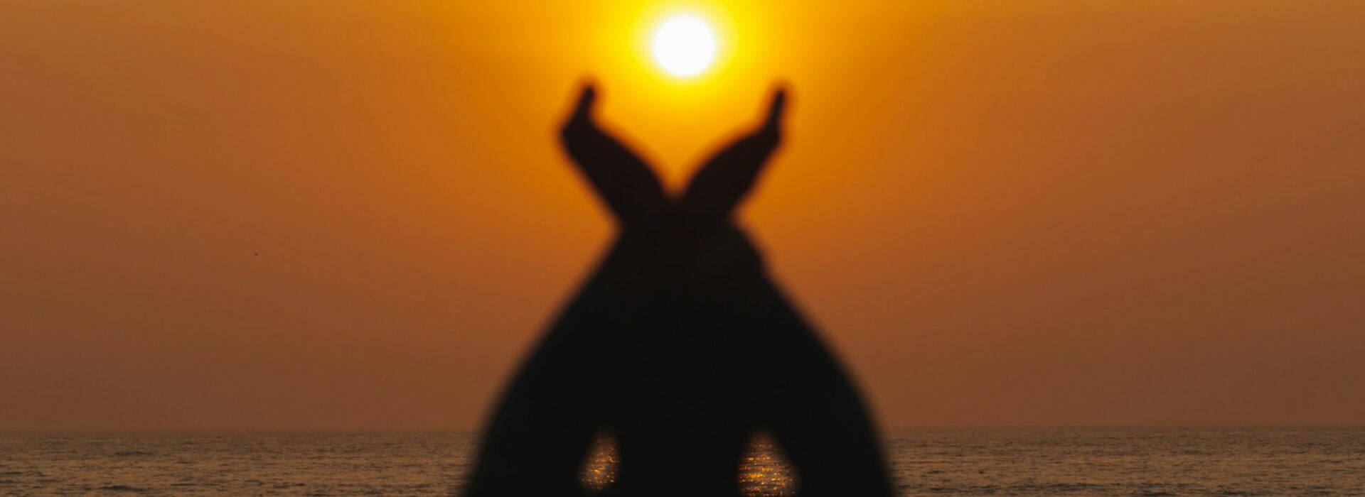 a person standing on a beach with their hands in the air